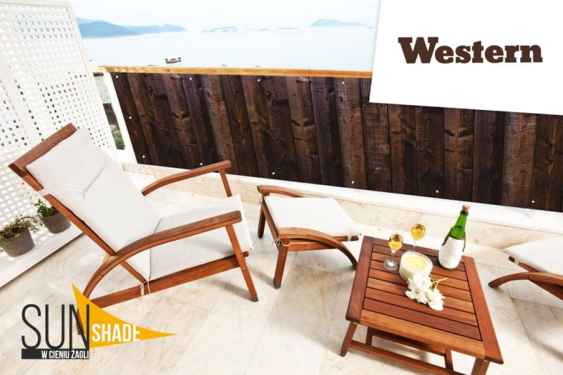 Osłona balkonowa Western 0,98x4,98 m o wzorze ciemnego drewna, zamontowana na balkonie z meblami ogrodowymi.