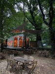 Żagiel przeciwsłoneczny przemysłowy wodoszczelny trójkąt nad stolikami w ogródku restauracyjnym.