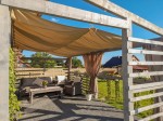 Wodoszczelny żagiel przeciwsłoneczny rozsuwany 1,5x5 m zamontowany na drewnianej pergoli tarasowej.