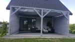 Szara boczna zasłona tarasowa o wymiarach 2,49x1,97 m osłaniająca altanę z grafitowymi meblami ogrodowymi.