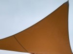 Wodoszczelny żagiel ogrodowy na wymiar w kolorze brązowym zamontowany na tle nieba. Solidny żagiel przeciwsłoneczny.