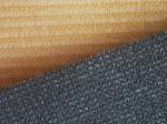 Zbliżenie na strukturę materiału HDPE, z którego wykonany jest żółty i szary żagiel przeciwsłoneczny.