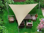 Piaskowy trójkątny żagiel wodoszczelny premium o wymiarach 4,2x4,2x5,9 m nad drewnianym zestawem mebli ogrodowych.