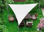 Trójkątny biały żagiel wodoszczelny premium 5,2x5,2x5,2m nad zestawem mebli ogrodowych na zielonej trawie.