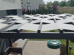Wodoszczelny pas altanowy 0,4x5 m zamontowany na drewnianej pergoli tarasowej w formie szarych przeplotów.