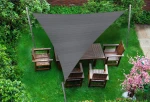 Szary trójkątny żagiel przeciwsłoneczny HDPE 3x3x4,2 m osłaniający drewniane meble ogrodowe na zielonym trawniku.