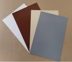 Próbki kolorów rzymskiej rolety poziomej PVC: biały, brązowy, beżowy oraz szary, ułożone na kartonie.