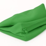 Zielony, rozpinany pokrowiec na poduszki ogrodowe wykonany z wytrzymałej tkaniny, widoczny zamek błyskawiczny.