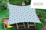 Wodoszczelny żagiel ogrodowy 3x5 m z nowoczesnym wzorem geometrycznym nad drewnianymi meblami na zielonym trawniku.