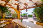 Wodoszczelny pas altanowy 0,5x5 m zamontowany na drewnianej pergoli nad tarasem z widokiem na morze i meblami ogrodowymi.