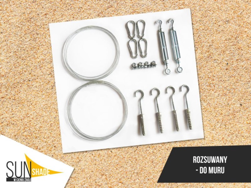 Zestaw montażowy do żagla rozsuwanego do muru: linki stalowe, śruby rzymskie, karabińczyki i haki z kołkami.