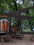 Wodoszczelny żagiel ogrodowy przemysłowy uszyty na wymiar, osłaniający stoliki w ogródku restauracyjnym.