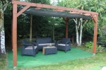 Brązowa drewniana pergola ogrodowa z meblami i rozsuwanym żaglem tarasowym z materiału HDPE uszytym na wymiar.
