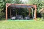 Brązowa drewniana pergola ogrodowa z szarym żaglowym dachem przeciwsłonecznym HDPE na wymiar i zestawem mebli.