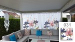 Zasłona firankowa na wymiar z grafiką 031 w kwiaty, zawieszona nad szarą kanapą narożną na tarasie.